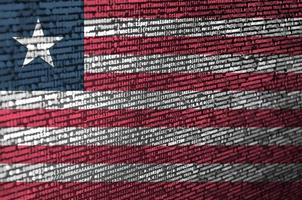 Die Liberia-Flagge wird mit dem Programmcode auf dem Bildschirm dargestellt. das konzept der modernen technologie und standortentwicklung foto