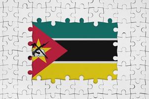Mosambik-Flagge im Rahmen aus weißen Puzzleteilen mit fehlendem Mittelteil foto