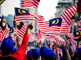 leute, die malaysische fahnen schwenken, feiern den unabhängigkeitstag foto