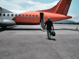 ein Mann, der allein zum Flugzeug am Terminak geht foto