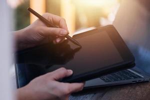 Geschäftsfrau arbeitet mit Laptop-Computer, Tablet und Smartphone im modernen Büro mit virtuellem Symboldiagramm im Modernoffice im Morgenlicht foto