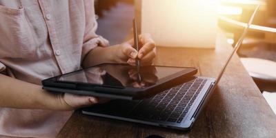 Geschäftsfrau arbeitet mit Laptop-Computer, Tablet und Smartphone im modernen Büro mit virtuellem Symboldiagramm im Modernoffice im Morgenlicht foto