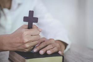 Frau mit Kreuz und Bibel in den Händen, die morgens um Segen von Gott betet, Spiritualität und Religion foto