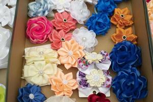 Blumen aus Haarstoff. Haarspangen in verschiedenen Farben. Stoffwaren für Dekorationszwecke. foto