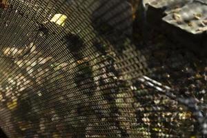 Mesh-Stahl-Textur. Gitter im Sonnenlicht. Zaun im Detail. foto