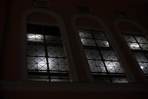 Fenster in der Nacht. Licht in den Fenstern am Abend. Gebäude draußen im Dunkeln. foto