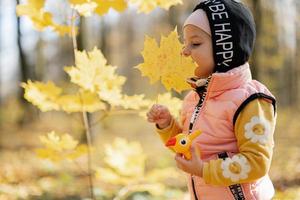 Herbstporträt im Freien eines schönen, glücklichen Mädchens im Wald mit Spechtspielzeug in den Händen, gegen gelbe Blätter. foto