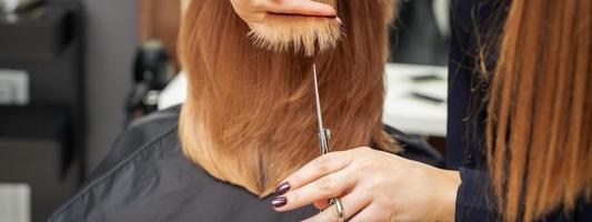 Friseur schneidet rote Haarspitzen foto