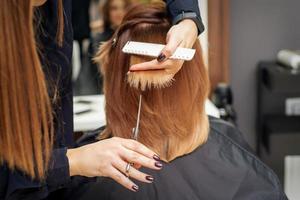 Friseur schneidet rote Haarspitzen foto