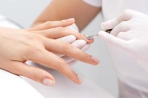 frau, die ein nagelpflegeverfahren erhält foto