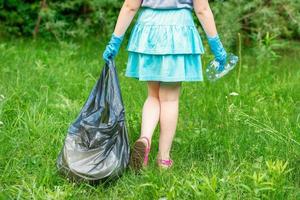 kleines Mädchen reinigt Plastikmüll foto