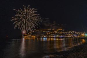 wunderbare reflexion des nächtlichen feuerwerks auf dem meer und stadtmeerblick foto