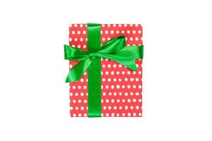 weihnachten oder andere feiertage handgemachtes geschenk in rotem papier mit grünem band. isoliert auf weißem Hintergrund, Ansicht von oben. Thanksgiving-Geschenkbox-Konzept foto