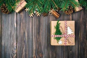 weihnachtsweinlese, getönter hintergrund mit tannenbaum und geschenkbox auf holztisch. draufsicht mit kopierraum für ihr design foto