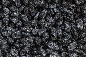 Schwarze Rosinentextur, beliebte Trockenfrüchte. getrocknete Trauben. foto