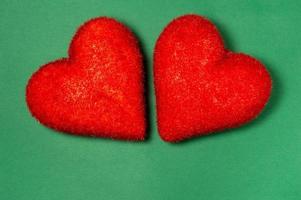 zwei rote Herzen auf grünem Hintergrund. postkarte zum valentinstag. Glückwunsch. romantischer Hintergrund. foto