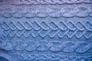 schöne Textur eines weichen, warmen, natürlichen Pullovers mit einem Strickmuster aus Fäden. der Hintergrund foto