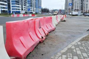 große, mit Wasser gefüllte, rote und weiße Gehäuseblöcke aus Kunststoff für die Verkehrssicherheit bei Straßenreparaturen foto