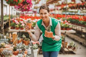 Floristin, die sich in einem Gartencenter um Sukkulenten kümmert foto