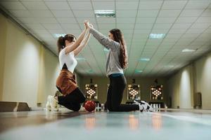 Freundinnen, die in einer Bowlingbahn feiern foto