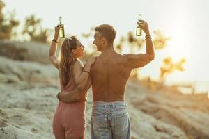 Paar genießt den Sonnenuntergang am Strand foto