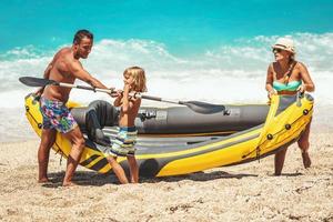 glückliche junge familie, die spaß am tropischen strand hat foto