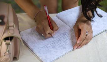 nahaufnahme mann hand halten stift schreiben auf weißem papier hochzeitstag. foto