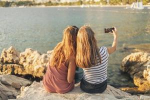 Zwei Freundinnen haben Spaß bei einem Videoanruf in den Sommerferien foto