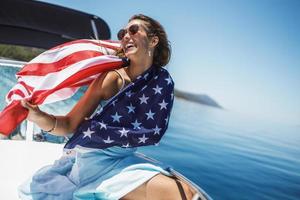 frau mit uns nationalflagge verbringt den tag auf einer privaten yacht foto