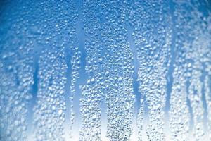 Textur von beschlagenem Glas im Winter. Gefrorene Wassertropfen in der Sonne am Fenster. foto