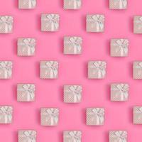 viele rosa geschenkboxen liegen auf texturhintergrund von modepastellrosa farbpapier in minimalem konzept. abstraktes trendiges Muster foto
