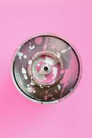 gebrauchte sprühdose mit rosa farbtropfen liegen auf texturhintergrund von modepastellrosa farbpapier in minimalem konzept foto