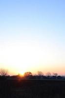 Morgendämmerung im Dorf. Sonnenaufgang in der Vorstadtlandschaft foto