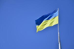 ukrainische Flagge gegen den blauen wolkenlosen Himmel. Die offizielle Flagge des ukrainischen Staates umfasst gelbe und blaue Farben foto