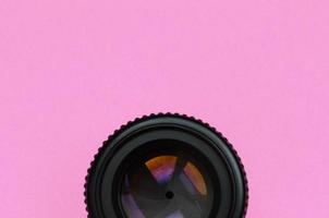 kameraobjektiv mit geschlossener blende liegen auf texturhintergrund von modepastellrosa farbpapier in minimalem konzept foto