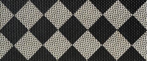 plastische Textur in Form eines sehr kleinen Stoffbandes, schwarz und grau bemalt im Stil eines Schachbretts. Makroaufnahme foto
