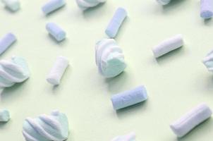 bunter Marshmallow auf hellgrünem Papierhintergrund. pastellfarbenes, kreatives Strukturmuster foto