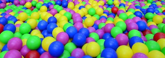 Viele bunte Plastikbälle in einem Bällebad für Kinder auf einem Spielplatz. Muster schließen foto