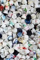 eine große Anzahl von Kappen aus Spraydosen für Graffiti. mit farbiger Farbe beschmierte Düsen liegen in einem riesigen Haufen foto
