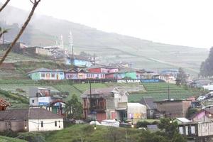Landschaftsfoto von Häusern am Fuße des grünen Berges foto