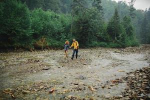 Verspieltes, glückliches, hübsches Paar, das beim Gehen im Wald hat. Touristen in den Bergen. Abenteuer im Naturkonzept. Paar in den Bergen foto