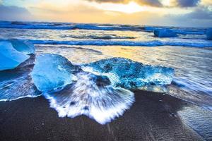 Eisfelsen mit schwarzem Sandstrand am Jokulsarlon-Strand oder Diamantstrand im Südosten Islands foto