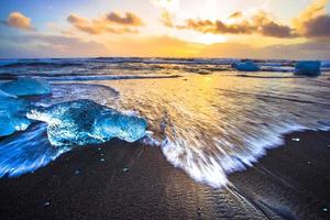 Eisfelsen mit schwarzem Sandstrand am Jokulsarlon-Strand oder Diamantstrand im Südosten Islands foto