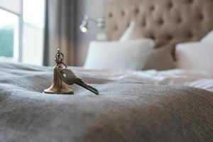 Schlüssel mit Schlüsselanhänger vom Hotelzimmer liegt auf dem Bett. foto