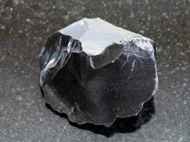 roher Obsidian-Vulkanglaskristall auf Dunkelheit foto