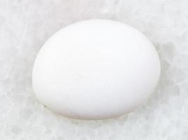 polierter cacholong weißer opaledelstein auf weiß foto