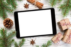 digitales tablet-modell mit rustikalen weihnachtlichen hölzernen hintergrunddekorationen für app-präsentation. draufsicht mit kopierraum foto