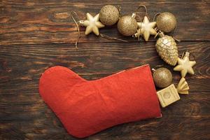 Goldkugeln und Spielzeug mit Weihnachtssocke auf Holzhintergrund foto