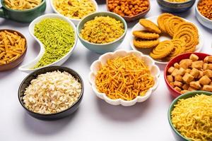 Indische Teezeit-Snacks in der Gruppe. Sev, Chivda, Farsan, Mischung, Bakarwadi in verschiedenen Schalen serviert foto