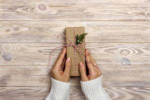 Frauen binden klassischen Bogen als Geschenk. hände der frau, die weihnachtsgeschenkbox verziert foto